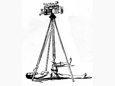 Man laying on back with tripod-mounted camera above